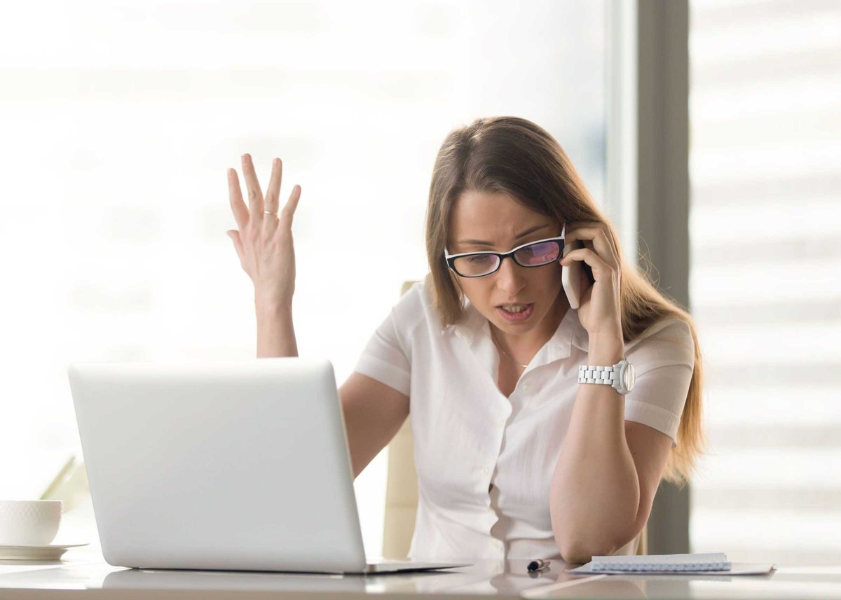 Disgruntled angry businesswoman arguing on cell phone sitting at
