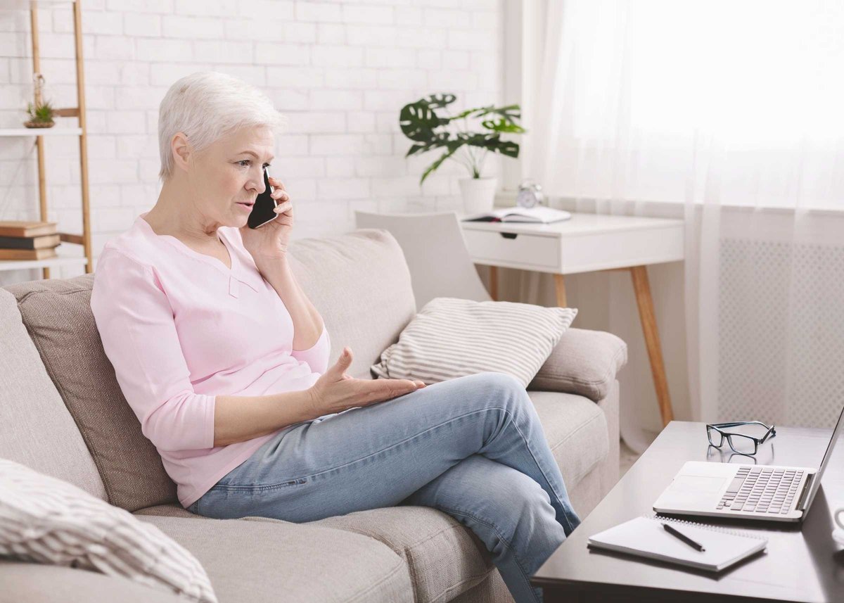 Angry senior woman complaining about problems with laptop