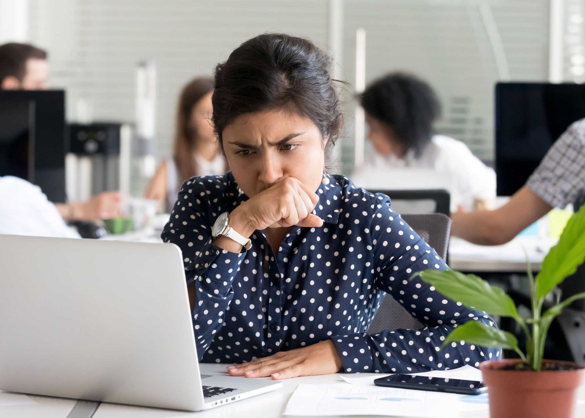 Focused Indian businesswoman looking at laptop screen