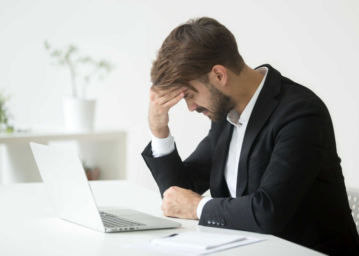 Depressed businessman shocked by bankruptcy failure sitting at w