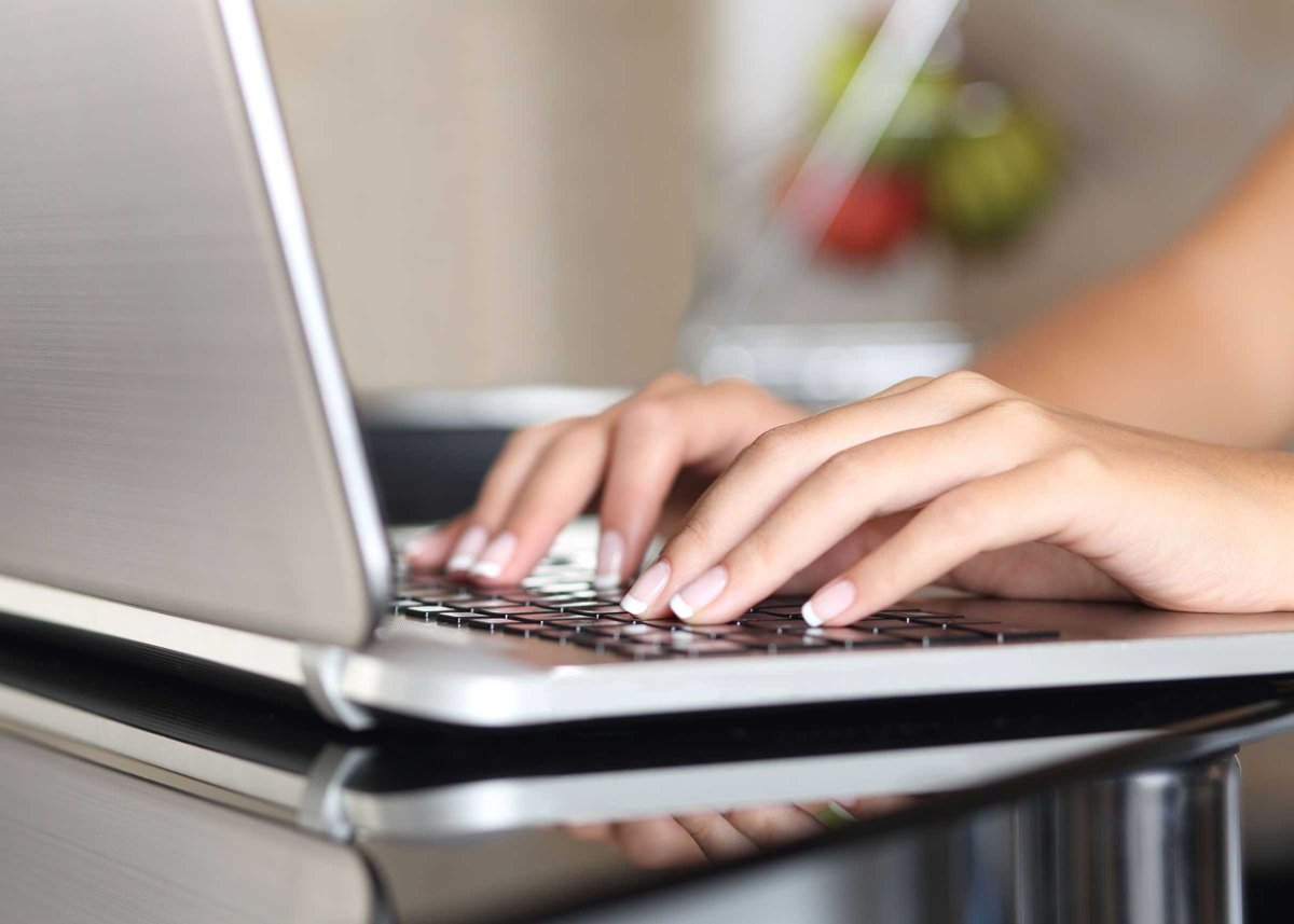 Woman hands working with a laptop at home