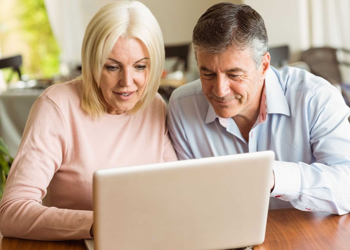 Happy mature couple using laptop