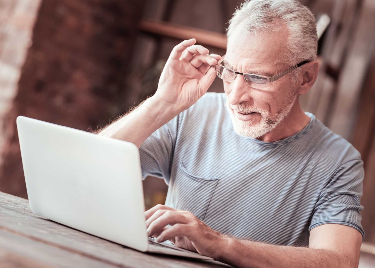 Close up of elderly man with a laptop