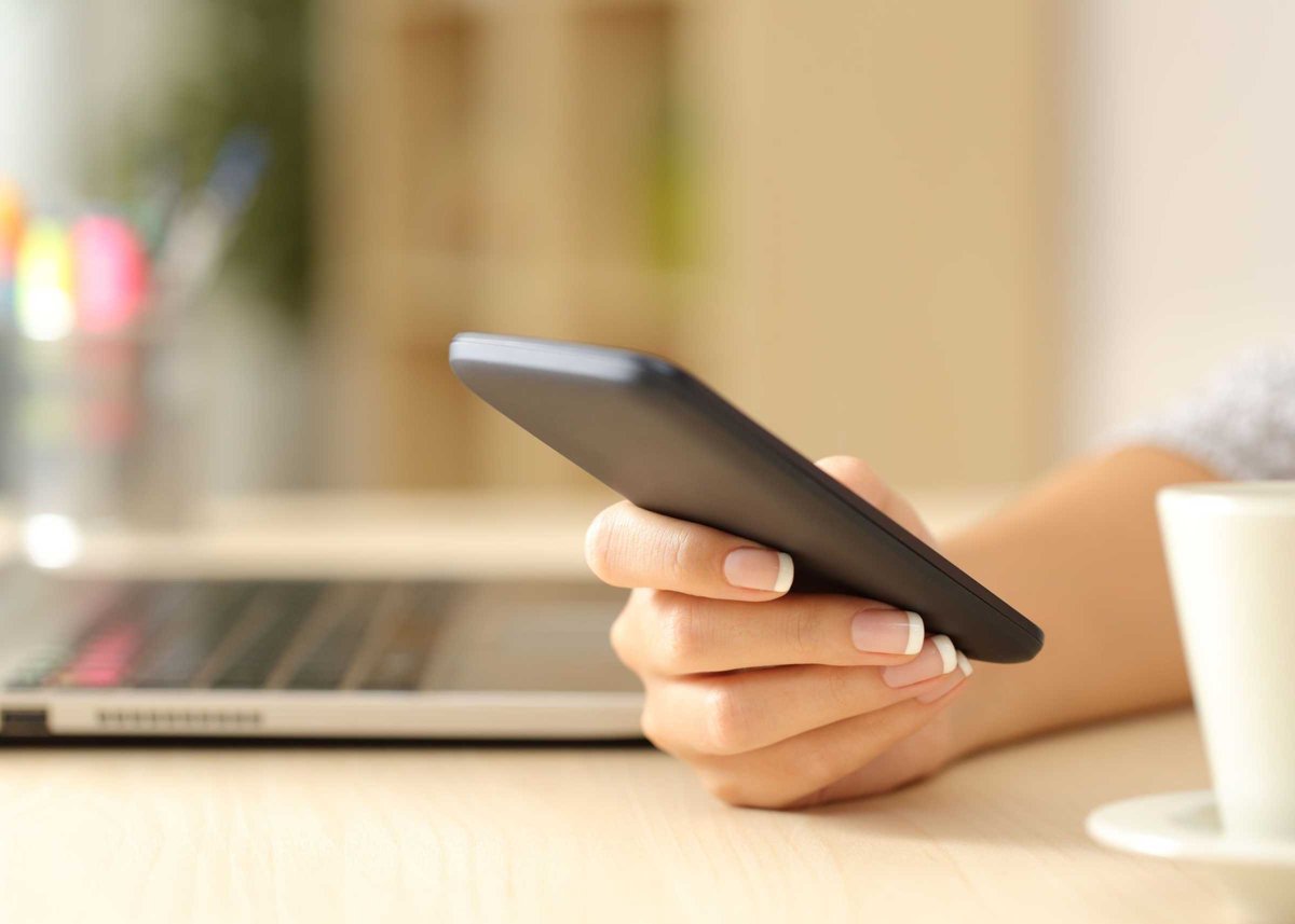 Woman hand using a smart phone on a desk