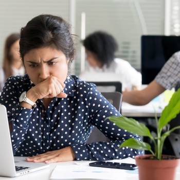 Focused Indian businesswoman looking at laptop screen