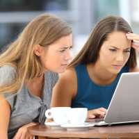 Two worried friends watching media content on line