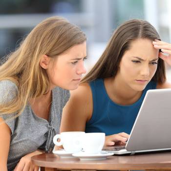 Two worried friends watching media content on line