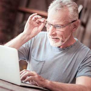 Close up of elderly man with a laptop