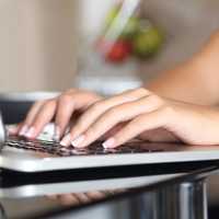 Woman hands working with a laptop at home