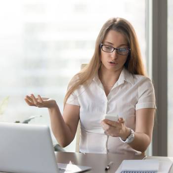 Indignant businesswoman having problem with not working smartpho