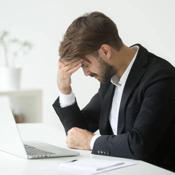 Depressed businessman shocked by bankruptcy failure sitting at w