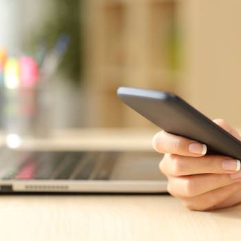 Woman hand using a smart phone on a desk